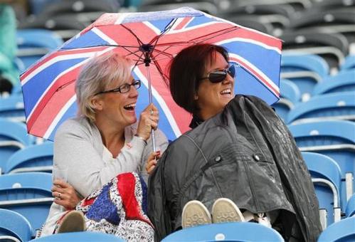 تماشاگران مسابقات اسب دوانی زیر باران به تماشای رقابت ها پرداختند. REUTERS/Mike Hutchings 