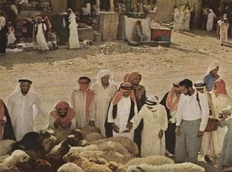 بازار خرید گوسفند برای قربانی کردن، عبد الغفور شیخ، تهیه کننده این عکس‌ها در اینجا با لباس غربی دیده می‌شود