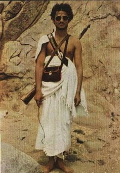 یک پلیس سعودی که در دست خود سیمی به دست دارد تا با آن حرکت حجاج را نظم ببخشد