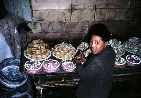 کودک افغان در یک شیرینی پزی مشغول تزئین کیک