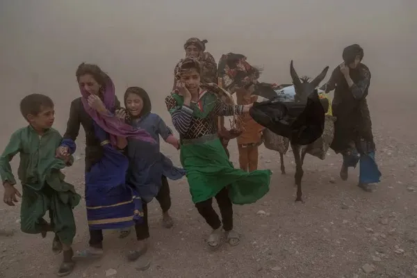  زنده جان، افغانستان ـ زنان و کودکان افغانی که در جریان طوفان شدید شن پس از زلزله در ولسوالی، کمک های اهدایی را به خیمه های خود می برند.