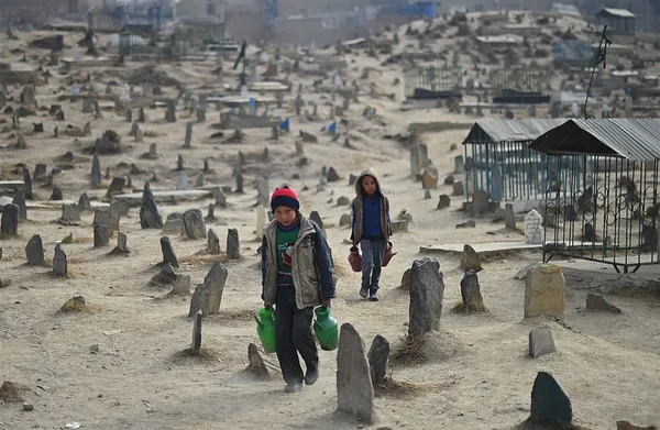 کودکان فروشنده آب در ویرانه&zwnj;های یک قبرستان در افغانستان./AFP - Getty Images
