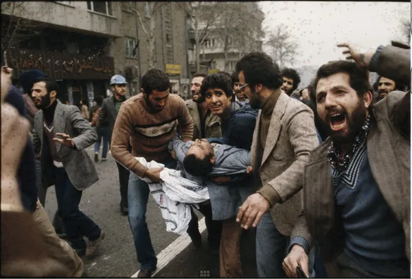 تظاهر کننده مجروح را به سمت آمبولانس می&zwnj;برند