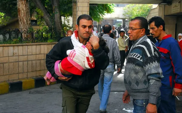 مرد سوری در حال انتقال کودک مجروحش به بیمارستان دمشق می باشد. انفجار یک بمب در ایستگاه راه آهن &laquo;الحجاز&raquo; که یکی از ایستگاه&zwnj;های شلوغ شبکه ریلی پایتخت سوریه به شمار می&zwnj;رود، چند شهروند بیگناه را کشته و تعداد دیگری را زخمی نمود
REUTERS/SANA/Handout via Reuters
