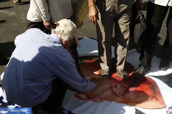 اعتراض به آمریکا با لگدمال کردن چهره رئیس دولت ایالات متحده بر روی بنر