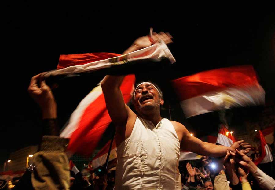 10 فوریه 2011/ یک معترض مصری در میدان التحریر قاهره، لحظاتی پس از انتشار بیانیه حسنی مبارک مبنی بر کناره گیری از قدرت، به شادی می پردازد/ (Photo by Chris Hondros/Getty Images