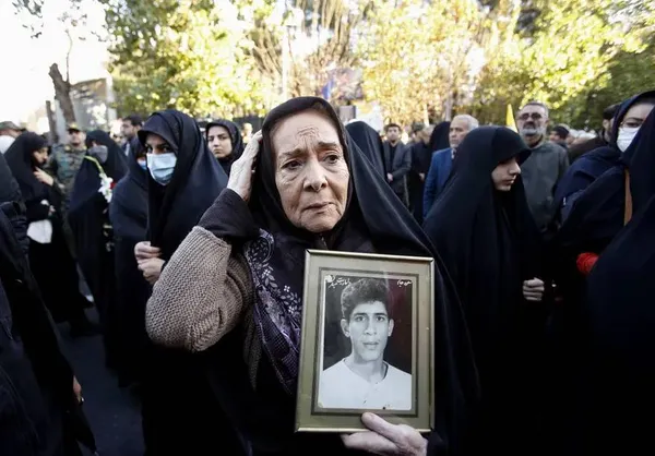 تهران، ایران ـ در مراسم بازگشت پیکرهای حدود 110 سربازی که اخیراً در عراق کشف شدند، مادری عکس پسر مفقود شده اش را در دست دارد.