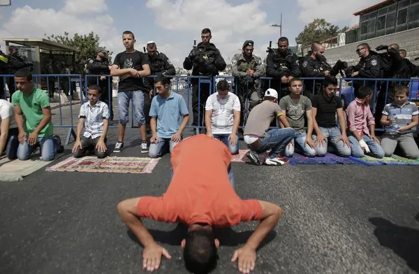 اقامه نماز جمعه  فلسطینیان در نزدیکی بیت المقدس و پلیس رژیم صهیونیستی در حال مراقبت از اوضاع منطقه./AFP
