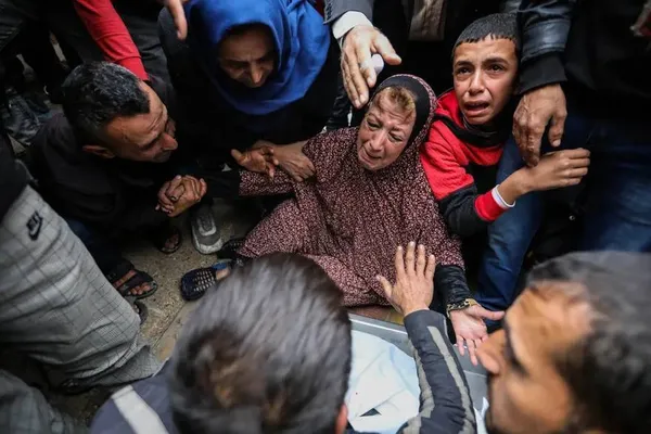 خان یونس، غزه ــ عزاداری مردم در کنار اجساد دوستان و اقوام شهید شده در یک حمله هوایی در 25 دسامبر.