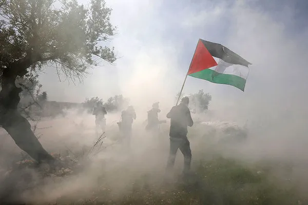 معترضان فلسطینی در جریان اعتراضات خود میان گاز اشک آوری که توسط رژیم صهیونیستی شلیک شده است.

