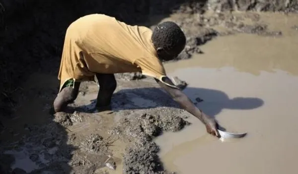 دختری از یک برکه گل آلود آب برمی&zwnj;دارد. اردوگاه پناهندگان جنوب &laquo;سودان&raquo;
