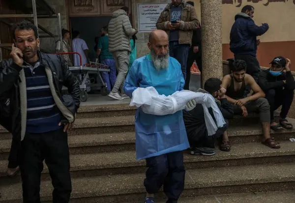 خان یونس، غزه
مردی در حال حمل جسد کودک خردسالی است که روز سه شنبه در حمله هوایی اسرائیل به خان یونس شهید شد.