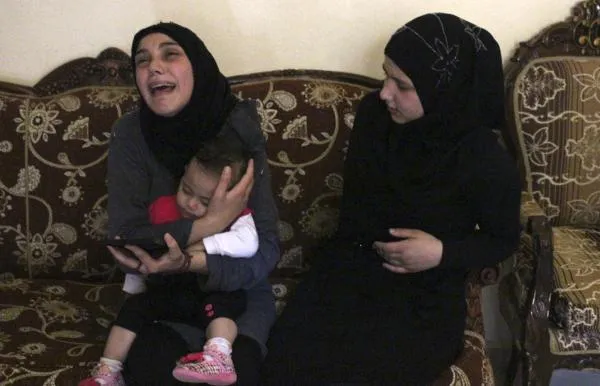 واکنش تلخ و حزن برانگیز همسر سرباز لبنانی علی السید، که توسط تروریست&zwnj;های تکفیری ـ سلفی داعش سر بریده شد، در حالی که فرزندشان در آغوش مادر ساکت نشسته است./Reuters
