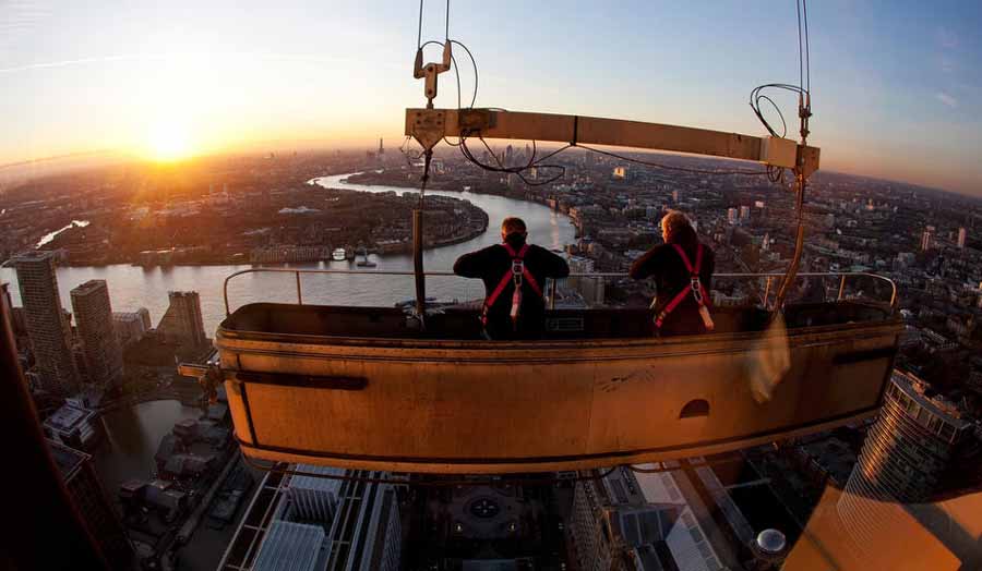 8 فوریه 2011، کارگران در حال تمیز کردن شیشه های برج Canary Wharf، یکی از بلندترین ساختمان های انگلستان در منطقه Dockland، تمیز کردن شیشه های این ساختمان 50 طبقه نزدیک به یک ماه زمان می برد و کارگران می بایست حتی در ارتفاع 325 متری هم کار کنند./ Photo by Matthew Lloyd/Getty Images)
