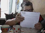 یک زن در نوارژینکا در حال بررسی برگه رای خود است.