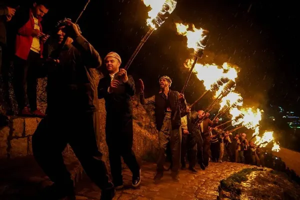 عکره، عراق ـ حمل مشعل توسط کردهای عراق هنگام جشن گرفتن نوروز؛ جشنی که اولین روز بهار و همچنین سال نو ایرانی است.