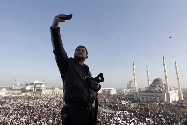 مردی در گروزنی، مرکز جمهوری چچن در حال گرفتن عکسی از خود و جمعیتی است که در مقابل مسجد شهر گرد آمده اند. در پی انتشار کاریکاتوری از پیامبر مسلمانان در نشریه فرانسوی شارلی ابدو، دهها هزار نفر از مردم این جمهوری در تظاهراتی در روز دوشنبه ۱۹ ژانویه شرکت کردند./REUTERS
