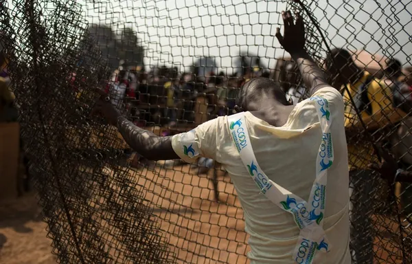 یک مرد پنجه در فنس&zwnj;های محافظ در اردوگاه آوارگان در فرودگاه بانجی جمهوری آفریقای مرکزی/Reuters
