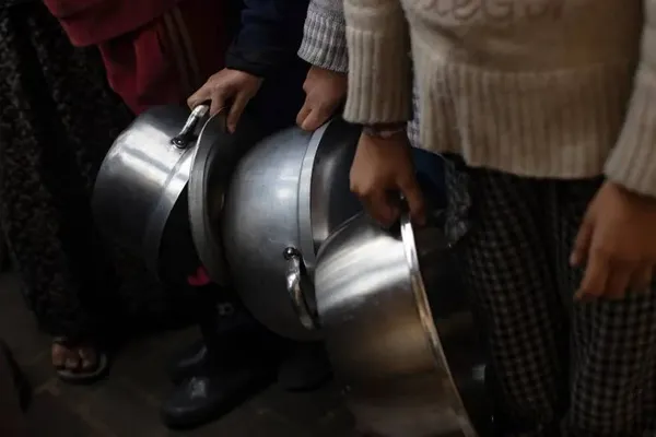 خان یونس، غزه ــ فلسطینیان در اردوگاه آوارگان برای دریافت غذای رایگان که توسط یک گروه از جوانان فلسطینی تهیه شده، صف می کشند.