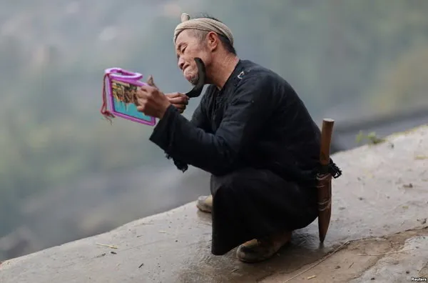 یک مرد چینی در روستایی در استان گوئیژوئوی این کشور مشغول اصلاح صورت خود با یک داس است. (Reuters)
