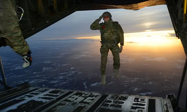ادای احترام نظامی یک سرباز آمریکایی هنگام پرش از هواپیما هرکول C-130 در جریان یک عملیات آموزشی- تمرینی در آسمان آلمان./U.S. Army
