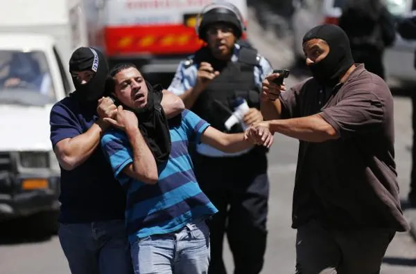 بازداشت خشونت آمیز جوان معترض فلسطینی به کشتار صهیونیستها در نوار غزه توسط دو مأمور سازمان امنیت رژیم اسرائیل در شرق بیت المقدس./Reuters
