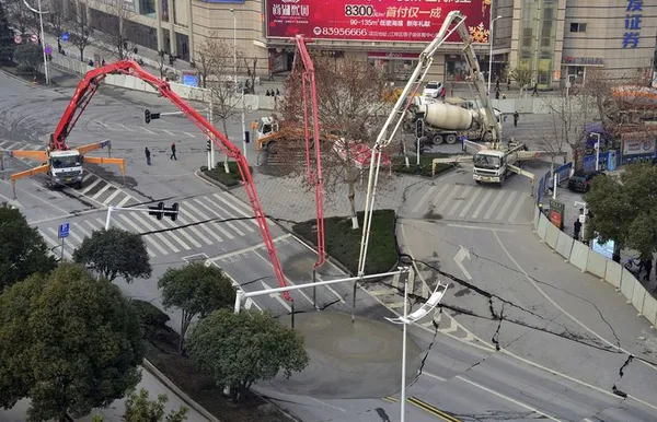 پدید آمدن یک گسل و ریزش آسفالت یک بزرگراه در ووهان، استان هوبئی چین و علمیات پر کردن گودال با تخلیه سیمان.
