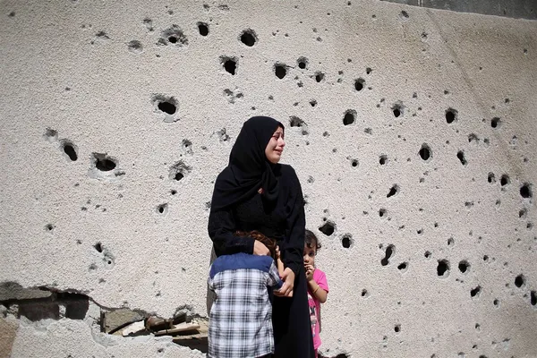شهروند فلسطینی ساکن خان یونس در جنوب نوار غزه، کنار دیوار در حزن شهادت دو نوجوان ۱۲ و ۱۶ ساله فلسطینی که در آخرین روز تهاجم صهیونیست&zwnj;ها به شهادت رسیده&zwnj;اند می&zwnj;گرید. /AFP - Getty Images