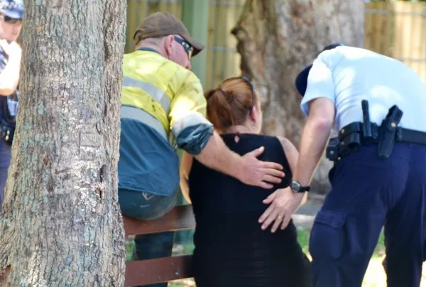 تصویر: ماموران امدادی و پلیس ساکنان محلی را آرام می&zwnj;کنند.جسد هشت کودک و زنی که بر اثر ضربات چاقو به شدت مجروح شده بود، جمعه ۲۸ آذر، در شهر کيرنز ايالت کوئينزلند استراليا پيدا شده است.به گزارش پليس استراليا اعلام کرده که زن ۳۴ ساله مجروح احتمالا مادر هفت کودک و از اقوام کودک ديگر باشد.کودکان کشته شده بين ۱۸ ماه تا ۱۵ سال سن داشتند./EPA
