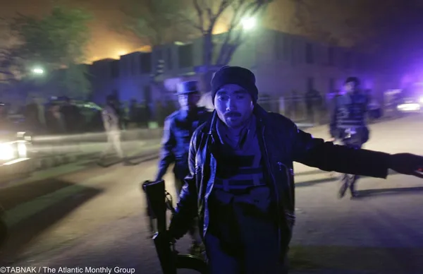 یک افسر پلیس افغان خود را به صحنه حمله راکتی در خارج از هتل سرنا در کابل می&zwnj;رساند (۲۰۰۹)